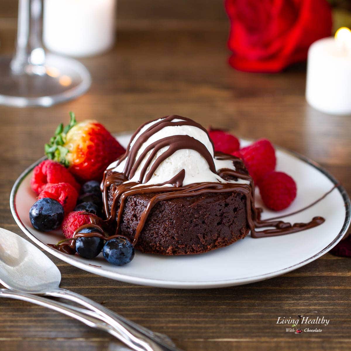 molten lava brownie with whipped cream berries and chocolate sauce on a plate